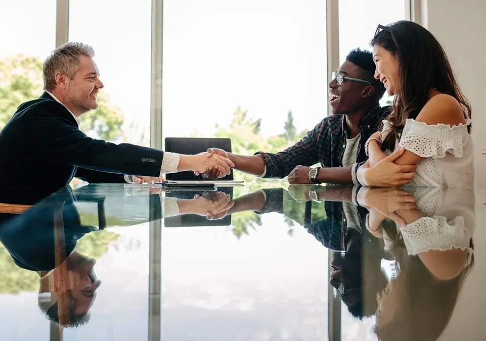 A man shaking hands with two other people.